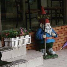 Giant garden gnome outside of a convenience store.