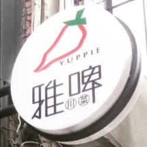 A sign of a restaurant called 'Yuppie' with a red chili pepper.